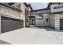 Modern home featuring a sleek garage door, stone facade, and contemporary architectural details at 5926 Hickory Oaks Trl, Castle Rock, CO 80104