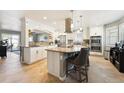 Bright, modern kitchen with stone countertops, an island with bar stool seating, and stainless steel appliances at 10622 Van Gordon Way, Broomfield, CO 80021