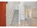 Bright foyer with a staircase, tiled entryway, and neutral decor at 18508 E Whitaker Cir # D, Aurora, CO 80015
