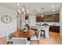 Open dining area with a round table and seating near the modern kitchen and stairs at 18014 Tree Sparrow Ave, Parker, CO 80134