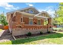 Lovely brick home showcasing a cozy front porch and well-maintained landscaping at 900 Jackson St, Denver, CO 80206