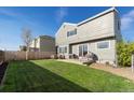 View of a well-maintained backyard with a lush lawn, patio, outdoor furniture, and a grill at 180 S Carlton St, Castle Rock, CO 80104