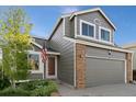 Well-maintained home exterior features a two-car garage and brick accents at 180 S Carlton St, Castle Rock, CO 80104