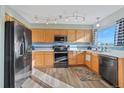 Bright kitchen featuring stainless appliances, wood cabinets, modern lighting, and tiled backsplash at 180 S Carlton St, Castle Rock, CO 80104