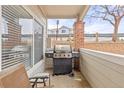 A condo porch features a stainless steel grill, a red brick support column and concrete flooring at 5537 Lewis Ct # 1, Arvada, CO 80002