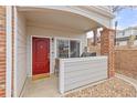 Cozy condo porch with a bright red door, a small grill, and a welcome mat at 5537 Lewis Ct # 1, Arvada, CO 80002