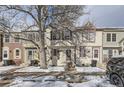 Charming townhome featuring a welcoming facade and wintery landscaping at 9651 W Cornell Pl, Lakewood, CO 80227