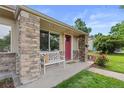 Close-up of the porch with stone pillars and a decorative white bench at 3064 S Grape Way, Denver, CO 80222