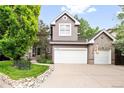 Charming two-story home boasts a two-car garage and attractive facade with manicured landscaping at 4756 E Pinewood Cir, Centennial, CO 80121