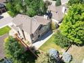 Backyard view features a stone patio and lush lawn, enclosed by a wood fence and mature trees at 16690 Amberstone Way, Parker, CO 80134