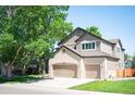 Two-story home boasts a two-car garage, a combination of brick and siding, and well-manicured landscaping at 16690 Amberstone Way, Parker, CO 80134
