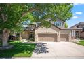 Charming home featuring a brick facade, three-car garage, and a lovely, mature tree in the front yard at 16690 Amberstone Way, Parker, CO 80134