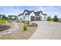 Two-story modern farmhouse with a three-car garage, landscaped yard, and stone pathway at 8263 Merryvale Trl, Parker, CO 80138