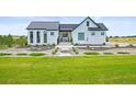 Inviting modern farmhouse with meticulous landscaping and a lush green lawn at 8263 Merryvale Trl, Parker, CO 80138