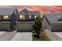 Charming two-story home with a two car garage, landscaped yard, and neutral siding at sunset at 19000 E 55Th Ave, Denver, CO 80249