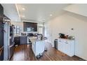 Open kitchen features stainless steel appliances, granite countertops, kitchen island, and ample cabinet space at 13589 E 102Nd Pl, Commerce City, CO 80022