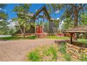Two story home boasts a red front door and mature trees at 14980 Elk Mountain Trl, Littleton, CO 80127