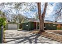 View of home and detached garage with driveway and shade tree at 2702 Atchison St, Aurora, CO 80011