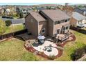 A spacious backyard featuring a patio with a dining set, a fire pit, and a well-manicured garden at 1678 S Parkdale Cir, Erie, CO 80516