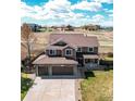 Stunning aerial view of a two-story home featuring an attached three-car garage, a well-manicured lawn, and beautiful landscaping at 1678 S Parkdale Cir, Erie, CO 80516