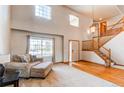 Bright living room boasts soaring ceilings, large windows, and a staircase with wooden rails at 1678 S Parkdale Cir, Erie, CO 80516