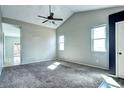 Spacious bedroom with carpet flooring, a vaulted ceiling, and an attached bathroom at 152 Pelican Ave, Brighton, CO 80601
