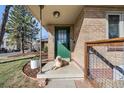 Inviting front porch with green door, brick accents, and a cute dog lounging in the sunshine at 2001 Grove St, Denver, CO 80211