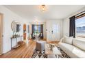 Bright living room featuring hardwood floors, modern furnishings, and an adjacent dining area at 2001 Grove St, Denver, CO 80211