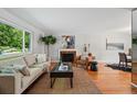 Inviting living room with hardwood floors, large windows, a cozy fireplace, and stylish neutral furnishings at 1905 S Linden Ct, Denver, CO 80224