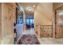 Bright foyer with tile flooring, staircase, and an open view into the living room with mountain views at 995 Nob Hill Rd, Evergreen, CO 80439