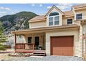 Charming two-story townhouse with covered porch and attached garage, set against a mountain view at 1795 Mountain Creek Dr, Georgetown, CO 80444