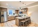 Well-lit kitchen boasts wooden cabinetry, a stainless-steel refrigerator, and a functional center island at 1810 Irving St # 4, Denver, CO 80204