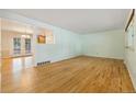 Bright living room featuring hardwood floors and an open layout to adjoining room at 8137 Vanguard Dr, Denver, CO 80221