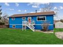 Charming blue two-story home with brown roof, white trim and fresh grass and welcoming front porch at 714 S Tabor St, Elizabeth, CO 80107