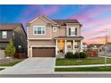 Beautiful two-story home with inviting front porch, lush lawn, and a colorful sunset backdrop at 502 Green Mountain Dr, Erie, CO 80516