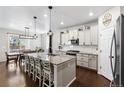 Bright, modern kitchen with a large granite island, stainless steel appliances, and pendant lighting at 502 Green Mountain Dr, Erie, CO 80516