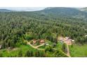 Beautiful aerial view of property with mature trees, multiple homes and a scenic mountain backdrop at 245 N County Highway 67, Sedalia, CO 80135