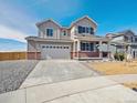 Charming two-story home with a covered front porch, a two-car garage, and professionally landscaped front yard at 10145 Quentin Ct, Commerce City, CO 80022