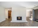 Spacious living room with a white brick fireplace, wood-look flooring, and a contemporary design at 500 Manhattan Dr # B1, Boulder, CO 80303