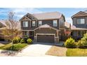 Charming two-story home features a well-maintained lawn and a two-car garage, complemented by a stone-accented facade at 12563 Grape St, Thornton, CO 80241