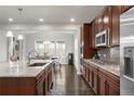 Modern kitchen boasts stainless appliances, dark wood cabinets, and granite countertops at 12563 Grape St, Thornton, CO 80241