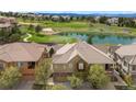 Aerial view of home with golf course and pond in backyard neighborhood setting at 10067 Bluffmont Ct, Lone Tree, CO 80124