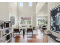 Bright living room with vaulted ceilings, hardwood floors, and large windows that offer great views at 10067 Bluffmont Ct, Lone Tree, CO 80124