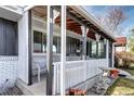 Close up of the covered front porch with a seating area and updated white brick exterior at 4070 W Exposition Ave, Denver, CO 80219