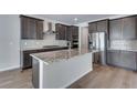 Gourmet kitchen boasts an island, stainless appliances, and dark cabinets at 13531 E 99Th Pl, Commerce City, CO 80022