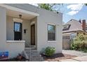 Exterior view of a gray painted brick house with steps leading to the front door at 914 E Iowa Ave, Denver, CO 80210