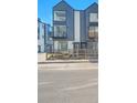 Modern three-story townhome with a black metal balcony and a small fenced-in yard at 1007 Chase St, Lakewood, CO 80214