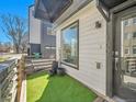 Close up of front yard with artificial turf, black planters, and the home's address at 1007 Chase St, Lakewood, CO 80214