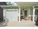 Inviting front porch features stone accents and decorative pillars, leading to the front door and attached garage at 6142 Gorham St, Frederick, CO 80530