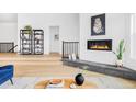 Cozy living room with a modern fireplace and an open floor plan offering a seamless flow to other rooms at 6251 N Galena St, Denver, CO 80238